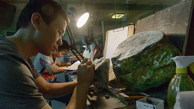 Artist marking up jade for carving