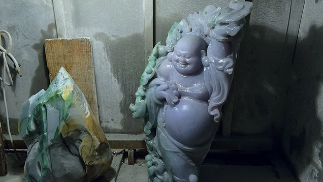 Jadeite carving at beginning stage alongside finished Buddha carving