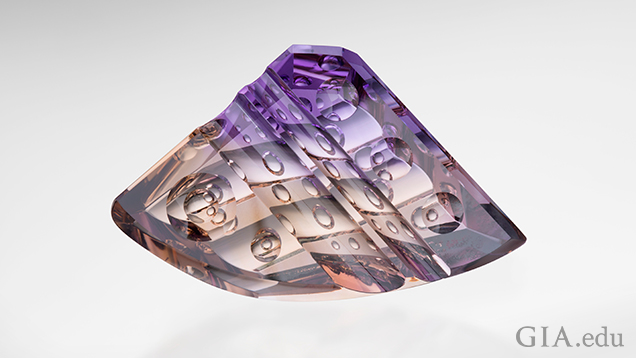 A triangular shaped carved piece of ametrine with a rounded bottom. “Bubbles” of internal carvings can be seen.