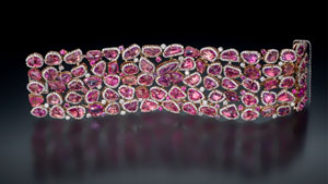 Fancy sapphire bracelet features 79 natural rose color sapphires and 24 round pink and purple heated sapphires. It is set in 18K rose and white gold accented with 12.52 total carat weight round diamonds. Courtesy of Omi Privé, photo by Robert Weldon/GIA
