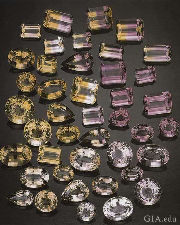 Arrangement of faceted citrine, amethyst, and ametrine gems in varying shades of yellow and purple from the Anahí mine crystals exhibit the November birthstone. 