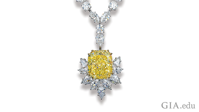 Image of large yellow diamond in setting with other white diamonds. 