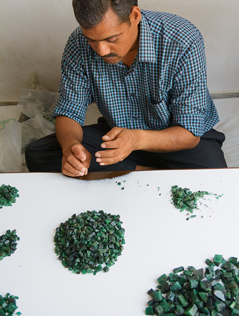 Man sorting rough emerald