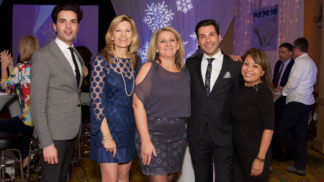 Five people stand in a row for photo.