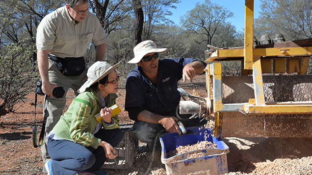 Three people with mining equipment