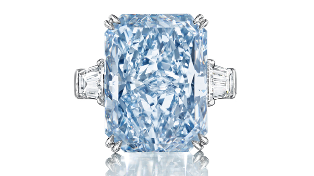 A 24.18 ct. cut-cornered, rectangular, mixed cut Fancy Intense blue diamond flanked with tapered baguette-cut diamonds.