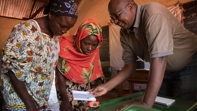 Marvin Wambua, GIA GG (right), helps participants in GIA’s pilot program examine a gem in the translucent tray included with the booklet Selecting Gem Rough: A Guide for Artisanal Miners. GIA and Pact, an NGO based in Washington, D.C., distributed the booklet and plastic trays to dozens of miners in the gem-rich Kalalani area of Tanzania in January 2017. Photo by Robert Weldon © GIA