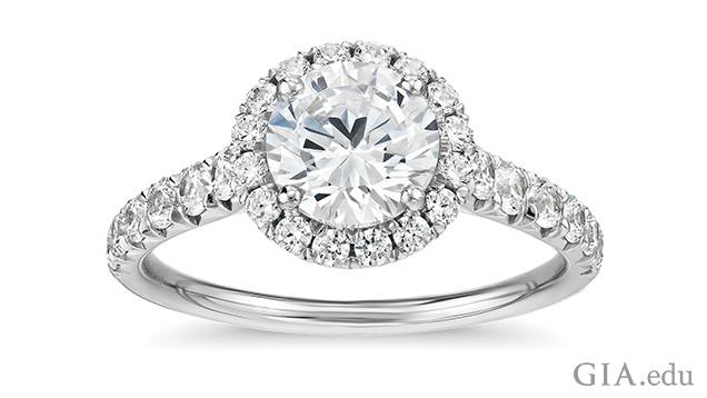 Image of engagement ring showing a single diamond surrounded by a halo of melee diamonds. 