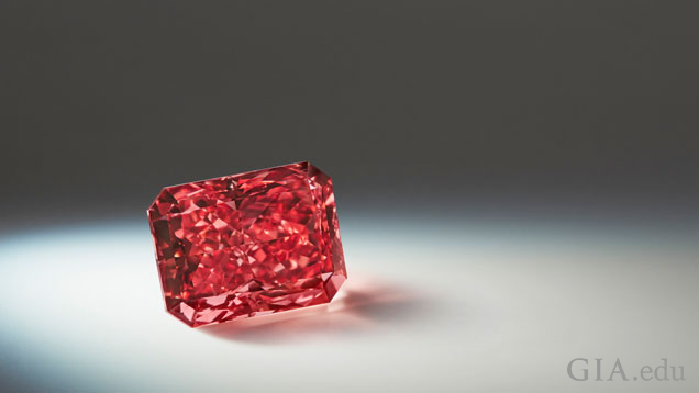 A 2.11 carat radiant shaped Fancy red diamond  in a spotlight