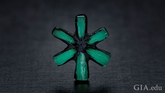 The six-spokes of a trapiche emerald remain after the carbonaceous material is cut away.