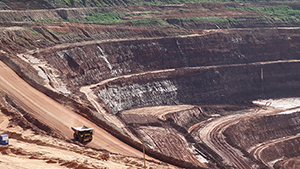 A truck travel the circular roadways of the large mine.