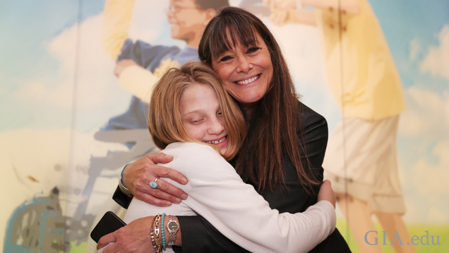 A woman hugs a young girl.