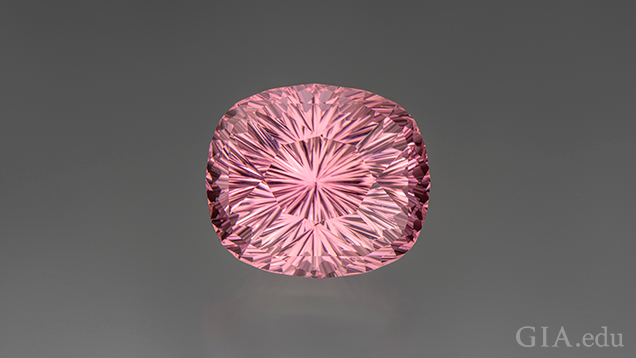 A rounded corners, rectangle-shaped piece of carved pink tourmaline.