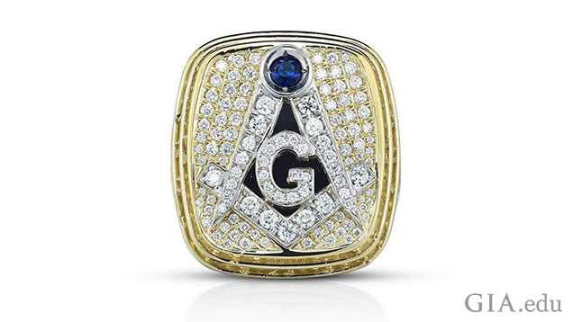 A square shaped yellow and white gold ring with masonic symbols.