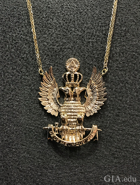 The pendant is in the form of two eagles sitting back to back, with wings spread and a crown on their heads.