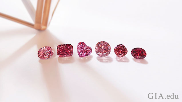 Six different shaped red and pink diamonds lined up in a row.