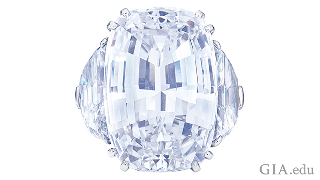 A 46.93 carat cushion step-cut diamond with half-moon modified brilliant-cut diamonds (one 3.64 ct and one 3.35 ct) on its sides.