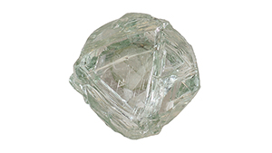 A piece of diamond rough with green body color and triangular etchings on the surface.