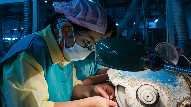 Worker sawing an preforming