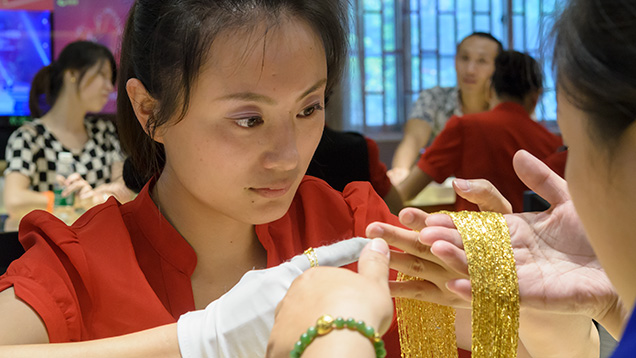 Sales associate holding gold jewelry