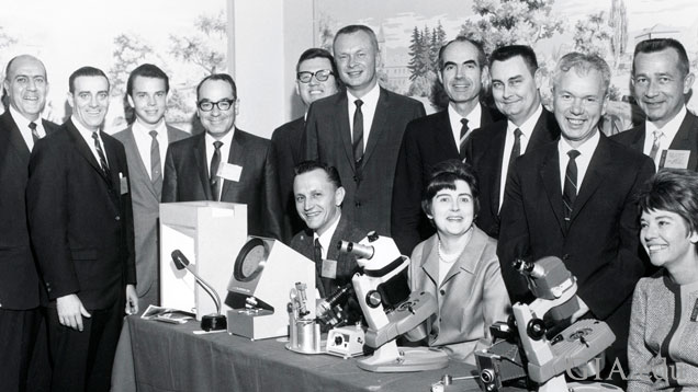 1968 年，GIA 员工在芝加哥参加美国宝石协会 (AGS) 秘密会议。站立人员左起：Bert Krashes（伯特·克拉什）、Joe Murphy（乔·墨菲）、John Charter（约翰·查特）、Richard T. Liddicoat（理查德·T·利迪科特）、Bob Ernest（鲍勃·欧内斯特）、Glenn Nord（格伦·诺德）、G. Robert (Bob) Crowningshield（G·罗伯特（鲍勃）克劳宁希尔德）、Chuck Fryer（查克·弗莱尔）、Ken Moore（肯·摩尔）和 Gale Johnson（盖尔·约翰逊）。就座人员左起：Steven Zack（史蒂文·扎克）, Eunice Miles（尤尼斯·迈尔斯）和 T.J. Barrows（T.J. 巴罗斯）。