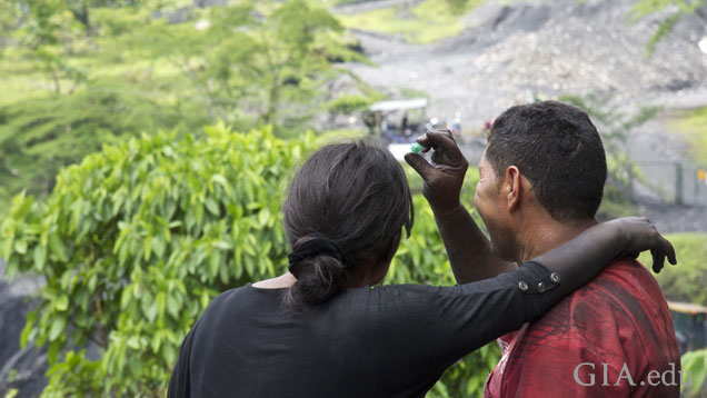 Husband and wife gaze happily at emerald rough found in a Colombian mine.