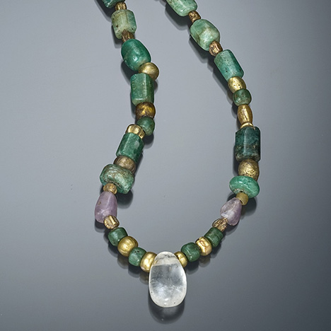 A quartz bead is the featured stone in this ancient Egyptian necklace. The strand consists of emerald, amethyst, and gold faience (a glazed ceramic). – Robert Weldon, on loan from the Royal Ontario Museum, Toronto, Canada