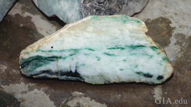 A piece of boulder shows ribbons of jade running through it.