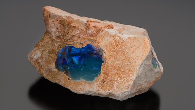 Black opal with blue play-of-colour in sandstone