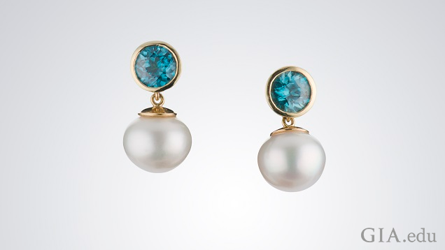 White pearls drop from round bezel set blue zircon.