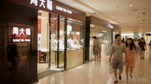 Shoppers walk in a mall past a Chow Tai Fook jewelry store.