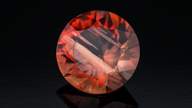 This fine 7.70-ct. red sunstone displays broad bars of aventurescent copper particles. - Robert Weldon 