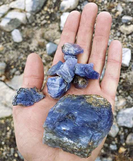 Figure 8. Freshly recovered rough chatoyant cordierite from the Thor-Odin dome. Note the lighter color and abundant acicular inclusions in the smaller fragments. Photo by Herb Hyder.