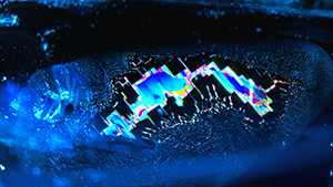 The rectilinear zigzag-patterned fingerprint in this 3.21 ct blue sapphire shows beautiful vibrant colors, indicating a Sri Lankan origin. Photomicrograph by Yuxiao Li; field of view 4.45 mm.