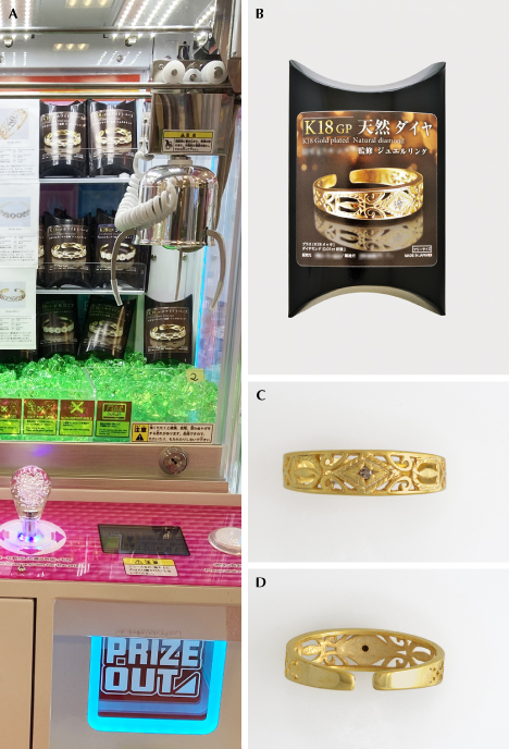 Figure 1. A: The arcade-style claw game. B: The diamond ring prize packaged in a paper box. C and D: The diamond ring shown from two angles: front view and back view. Photos by Mari Sasaki (A) and Shunsuke Nagai (B–D).
