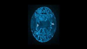 Figure 1. The 2.50 ct diamond in a dark environment around 10 s after deep-UV excitation to showcase its phosphorescence. Photo by Nick “Ka Chun” Chan.