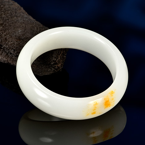 Figure 1. A high-quality Russian white nephrite bracelet, measuring approximately 58 × 13 × 7 mm, with the orange peel effect observable in its reflective areas. Photo by Zuojiang Chen.