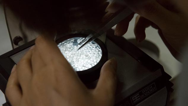 In a simple instrument called a polariscope, these diamonds are being checked for strain that could cause breakage.