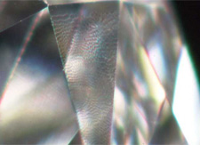 A transparent, uneven texture confined to one facet caused by polishing a facet off-grain