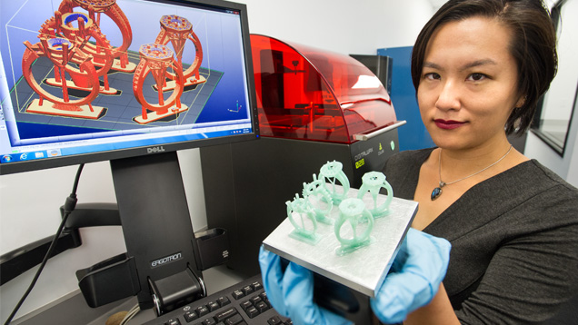Michelle Loon, a recent graduate of GIA’s Jewelry Design Technology program, holds the build platform containing the 3-D-printed resin prototypes of her jewelry design. Photo by Kevin Schumacher