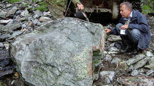 Jade expert examining a giant piece of nephrite