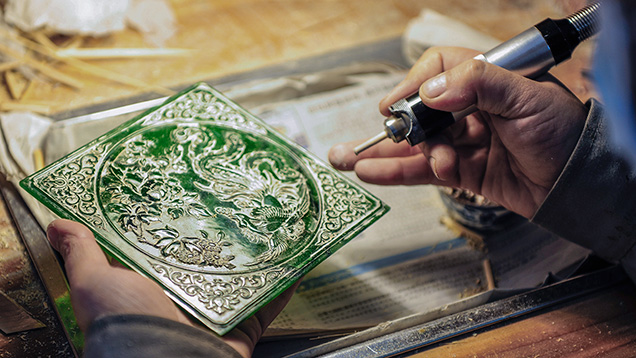 Carving a plaque of green nephrite