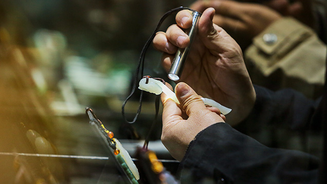 Examining a piece of white nephrite before an auction