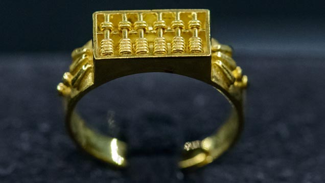 This is a replica of a Qing dynasty ring, once used as a gift from the mother-in-law to the new daughter-in-law, expressing wishes that she become a smart wife who benefits the family economically. By applying fine gold art, each small bead on the abacus can move freely. Photo by Eric Welch/GIA.