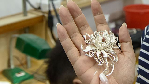 In the molding department of her jewelry manufacturing studio in Shenzhen, Shirley displays a silver mold of one of her designs.