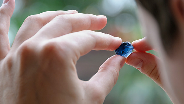 Examining a blue spinel crystal