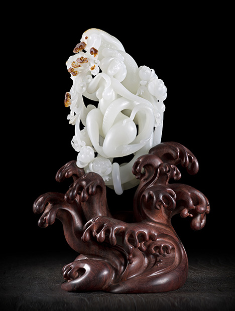 Openwork and Qiaose crafts are utilized in this white nephrite jade carving titled “Snake Girl.”