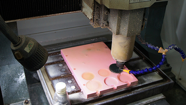 Tabular nephrite being engraved by a three-shaft CNC machine.