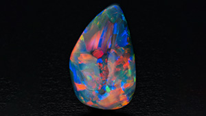 A 10.65 ct black opal from Lightning Ridge shown in diffused and direct lighting.