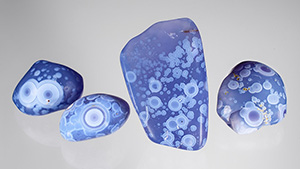 Figure 1. This relatively new type of violet chalcedony from Ethiopia (here, 75–198 ct) displays a wonderful pattern of white orbs. Photo by Annie Haynes; courtesy of Orbit Ethiopia Plc. 